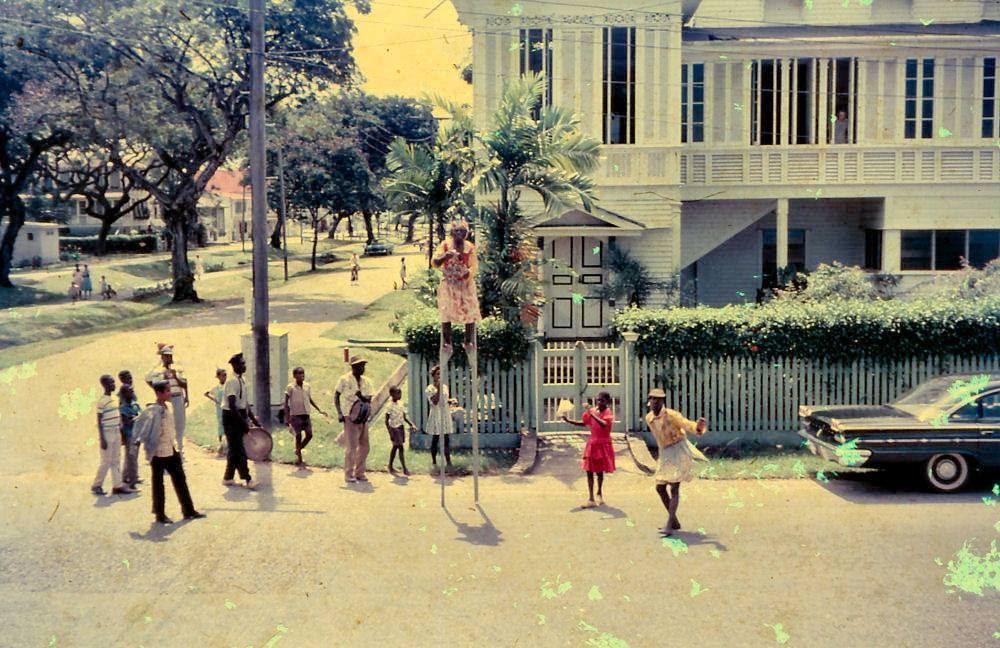Masquerade in Georgetown, Guyana around 1963.
Photograph shared by Wayne McWatt. Where is this location?  What attracts your attention?